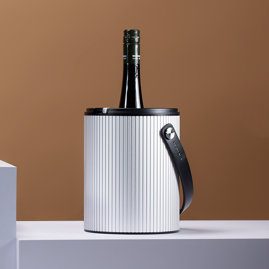 Wine bottle in a metallic ice bucket against a brown background